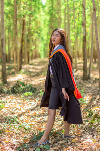 Portrait of young woman standing on field 