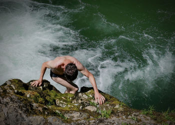 High angle view of shirtless man in sea