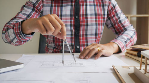 Midsection of man working on table