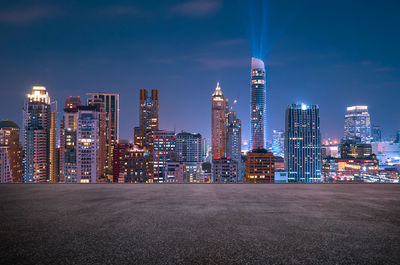 Illuminated buildings in city against sky at night