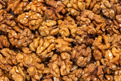 Full frame close-up background of walnuts pile without shells