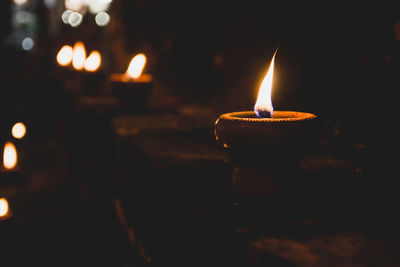 Close-up of lit candle in the dark