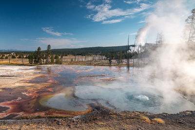 Smoke emitting from geyser against sky