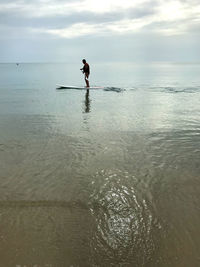 Man in sea against sky