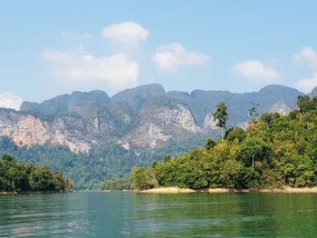 Scenic view of lake by mountains against sky