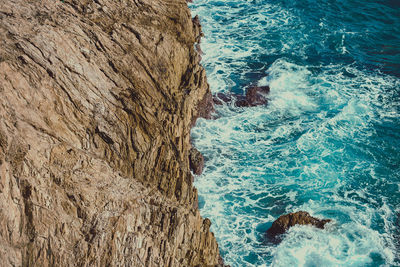 Rocky seashore against wavy sea