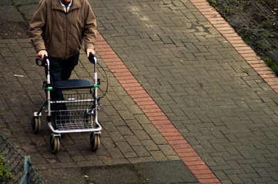 Low section of man using mobility walker on street