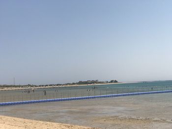 Scenic view of beach against clear blue sky