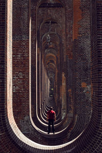 Rear view of man walking against building