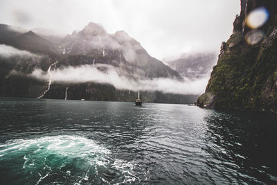 Scenic view of sea and mountains against sky