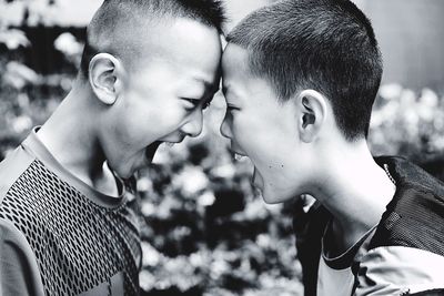Side view of boys shouting while looking face to face