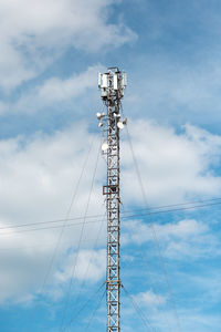 Low angle view of communications tower against blue sky