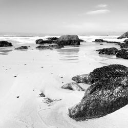 Scenic view of rocks on beach against sky