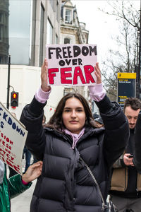 Portrait of young woman with arms raised