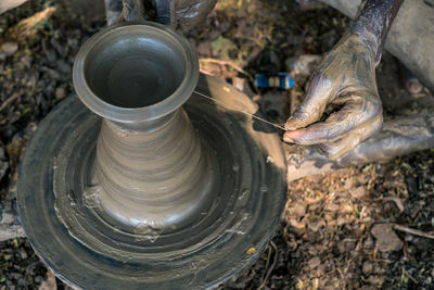 High angle view of hands working on pottery wheel