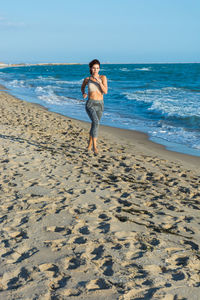 Full length of boy on beach against sky