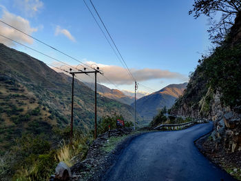 Road amidst plants and mountains against sky