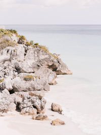 Scenic view of rocks on beach against sky