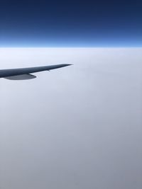 Airplane flying over sea against sky