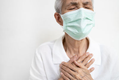 Midsection of man wearing mask against white background