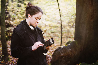 Teenage girl looking at camera while standing on land