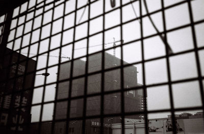 Low angle view of building seen through glass window