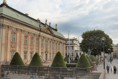 Buildings in city against cloudy sky