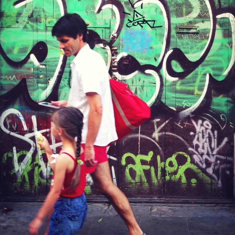 lifestyles, leisure activity, casual clothing, person, graffiti, young adult, full length, happiness, three quarter length, fun, communication, standing, young women, portrait, boys, wall - building feature