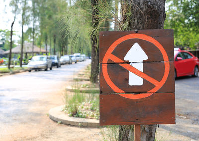 Close-up of arrow sign on road in city