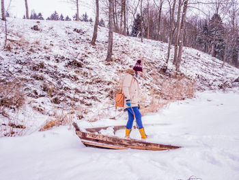 Woman walking on snow covered field