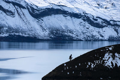 Silhouette of one person climbing mountain