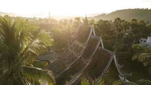 High angle view of temple by palm trees against sky