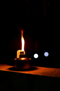 Close-up of lit candle in the dark