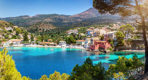 Scenic view of sea by buildings against sky