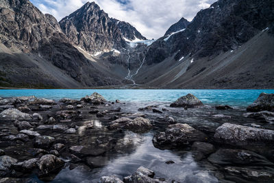 Scenic view of lake by mountains against sky