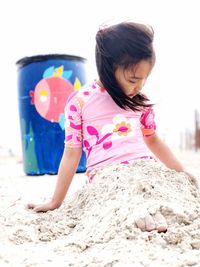 Cute girl playing with sand at beach