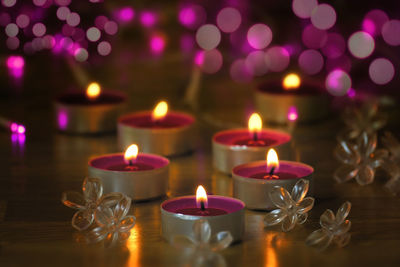 Close-up of lit tea light candles on table