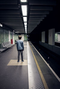 Rear view of man on railroad station platform