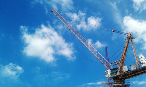 Low angle view of crane against sky
