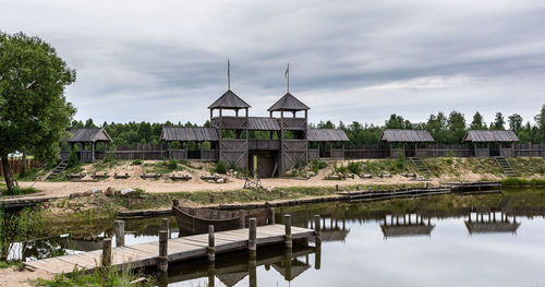 Picturesque medieval scenery near the lake with old wooden defensive wall and pier
