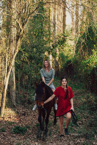 Women with horse in forest