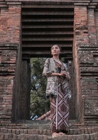 Thoughtful young woman standing on steps