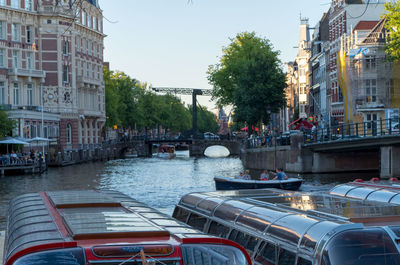 Canal amidst buildings in city against sky