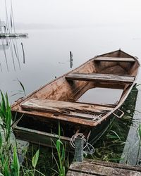 Abandoned boat moored on lake shore