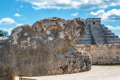 Close-up of sculpture against kukulkan pyramid