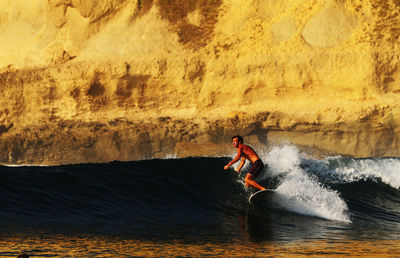 Man surfing in sea against sky