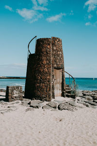 Built structure on beach against sky