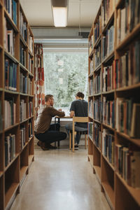 Professor explaining student studying in library at university