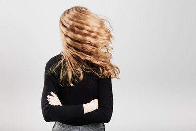 Teenage girl with tousled hair against white background