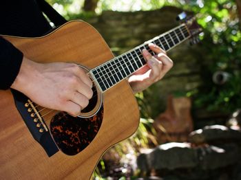 Cropped hands of man playing guitar